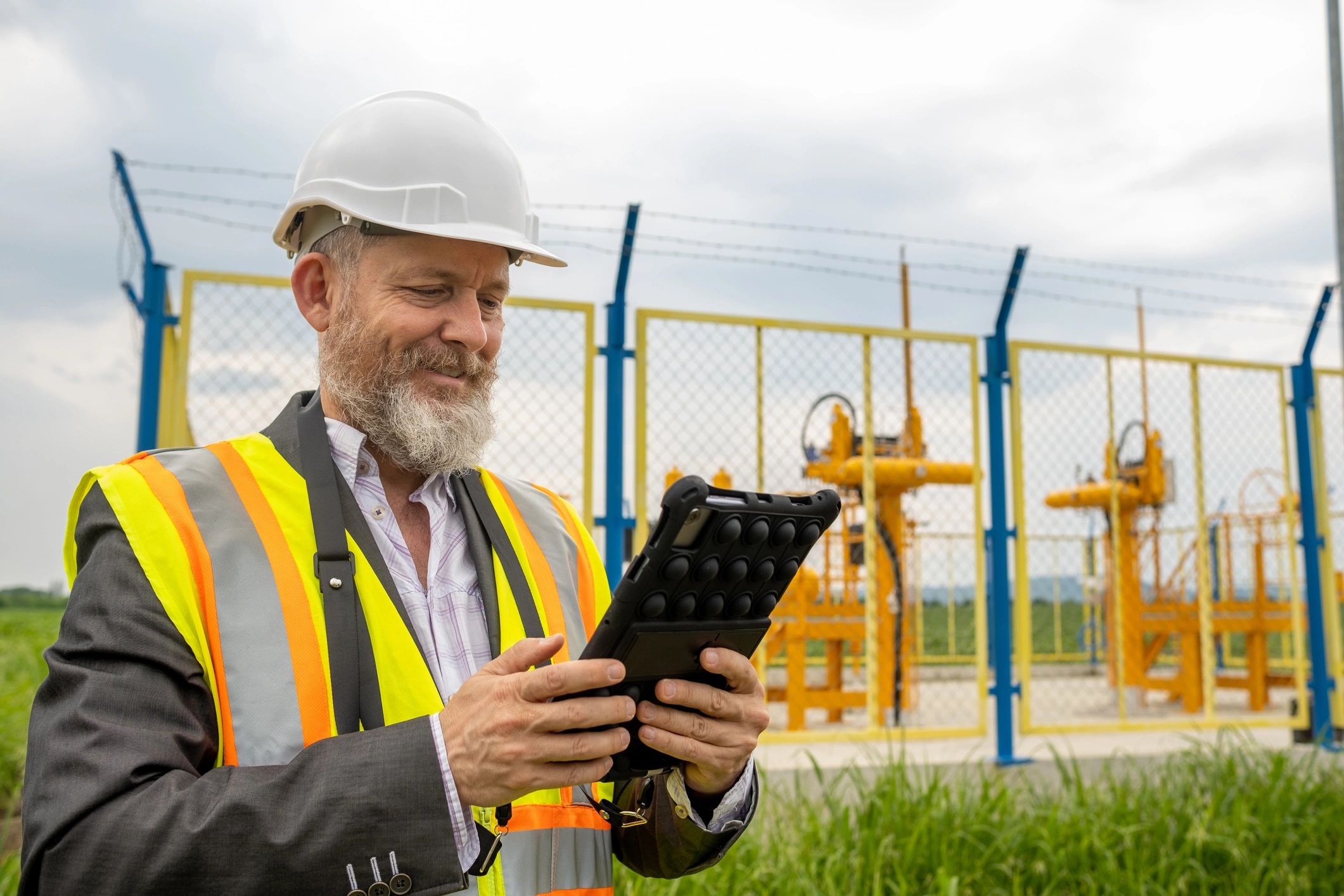 Middle-aged oil and gas foreman in safety gear at a pipeline control station